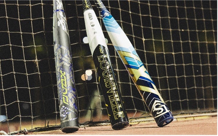 A group of baseball bats leaning against a net
      
      Description automatically generated